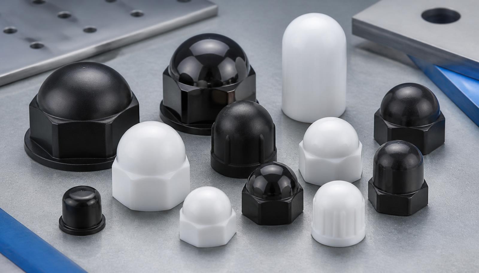 Capuchons de protection en plastique noirs et blancs en PE, PP et PVC alignés sur un plan de travail